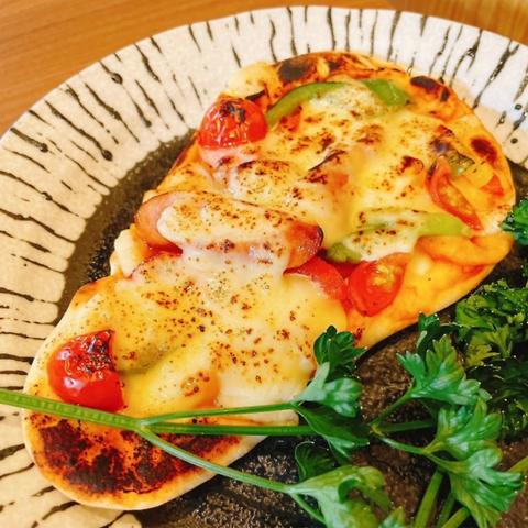 チーズとトマトをのせて焼いたナンピザ