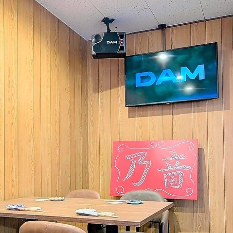 乃音の看板とカラオケの画面がある壁